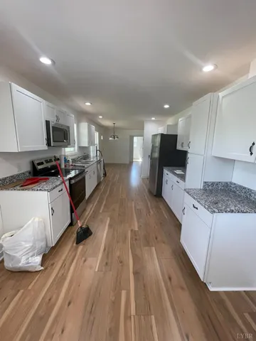 a kitchen with stainless steel appliances kitchen island granite countertop a stove a sink and a microwave