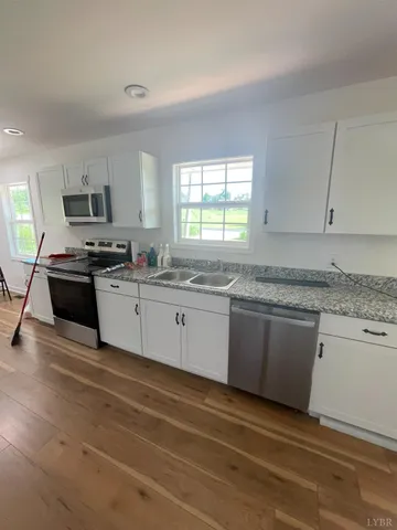 a kitchen with stainless steel appliances granite countertop a stove a sink and a granite counter tops