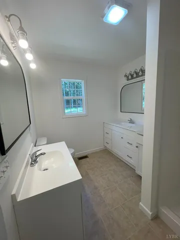 a bathroom with a sink a toilet and mirror