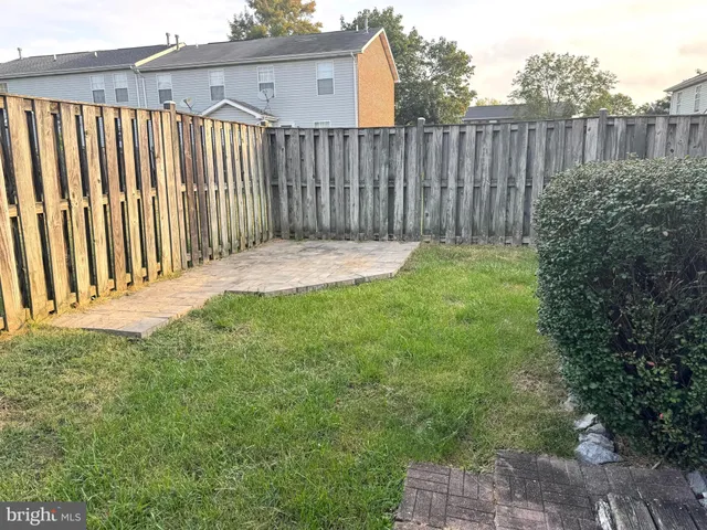 a view of a backyard with wooden fence