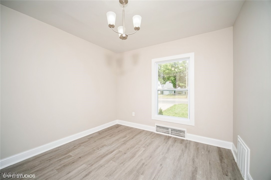 2188 North Taylor Road Cleveland Heights, OH 44112 - Photo 4 of 15 Unfurnished room featuring a chandelier and wood finished floors