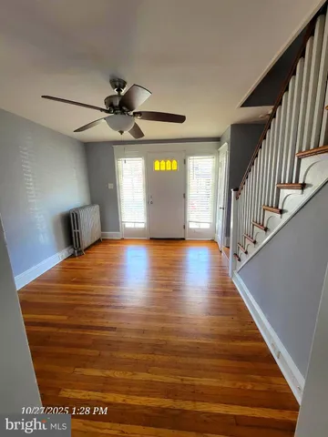 a view of a room with wooden floor staircase and a ceiling fan