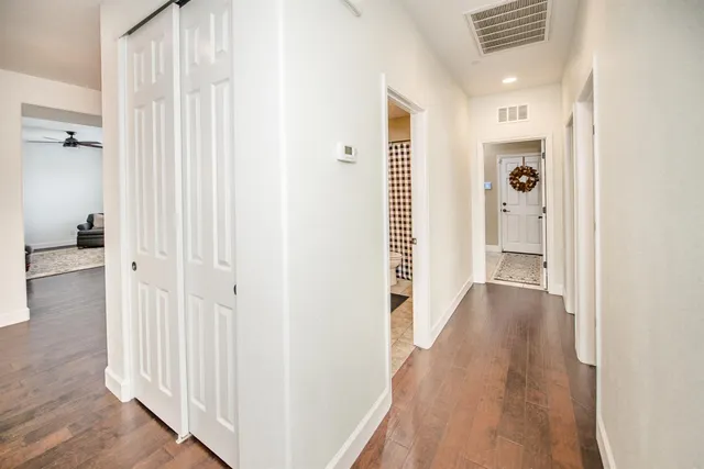 a bathroom with a granite countertop sink a toilet a mirror and shower curtain