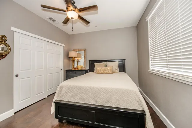 a bathroom with a granite countertop sink vanity mirror and toilet