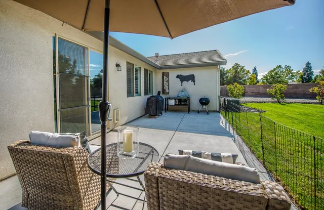 a backyard of a house with table and chairs