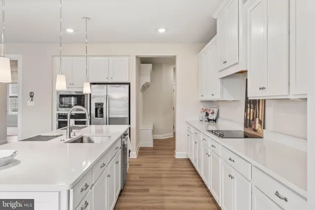 a large kitchen with stainless steel appliances kitchen island granite countertop a sink and cabinets