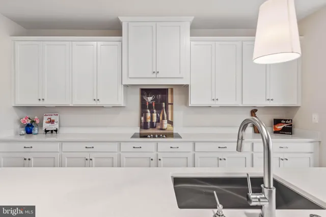 a kitchen with white cabinets and sink