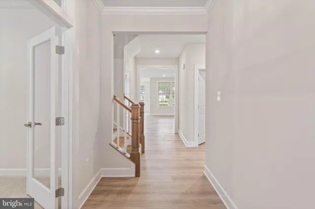 a view of a hallway with wooden floor and staircase