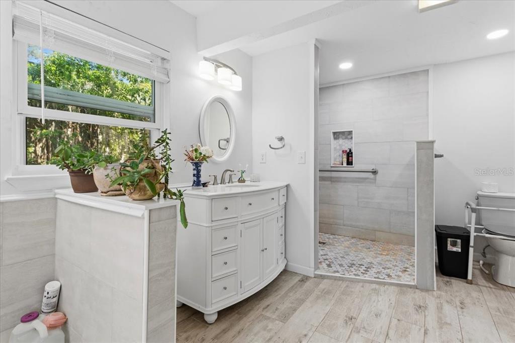 8386 Austin Road Melrose, FL 32666 - Photo 29 of 76 a bathroom with a double vanity sink mirror and shower