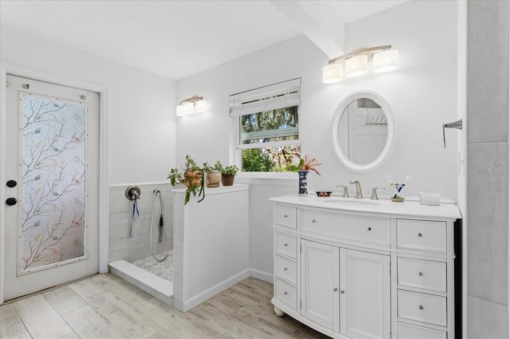 8386 Austin Road Melrose, FL 32666 - Photo 30 of 76 a bathroom with a double vanity sink mirror and shower