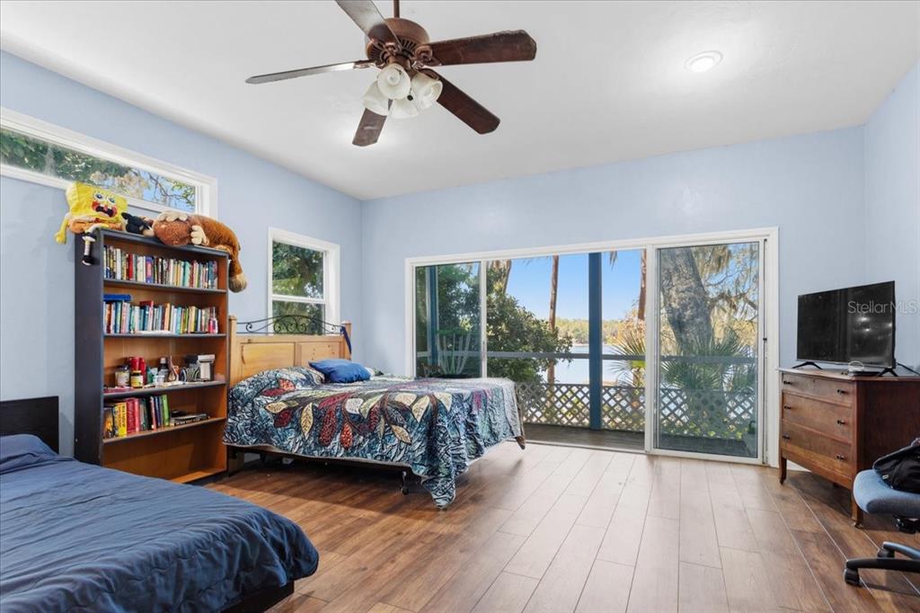 8386 Austin Road Melrose, FL 32666 - Photo 44 of 76 a bedroom with a bed a bookshelf and a flat screen tv
