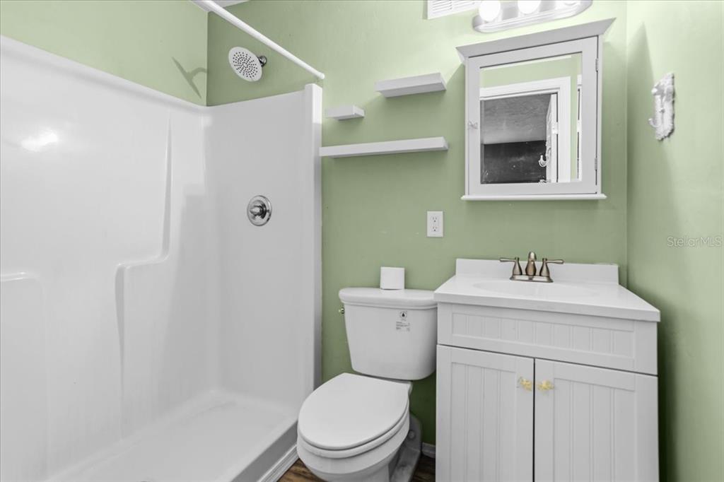 8386 Austin Road Melrose, FL 32666 - Photo 65 of 76 a bathroom with a toilet sink vanity and mirror