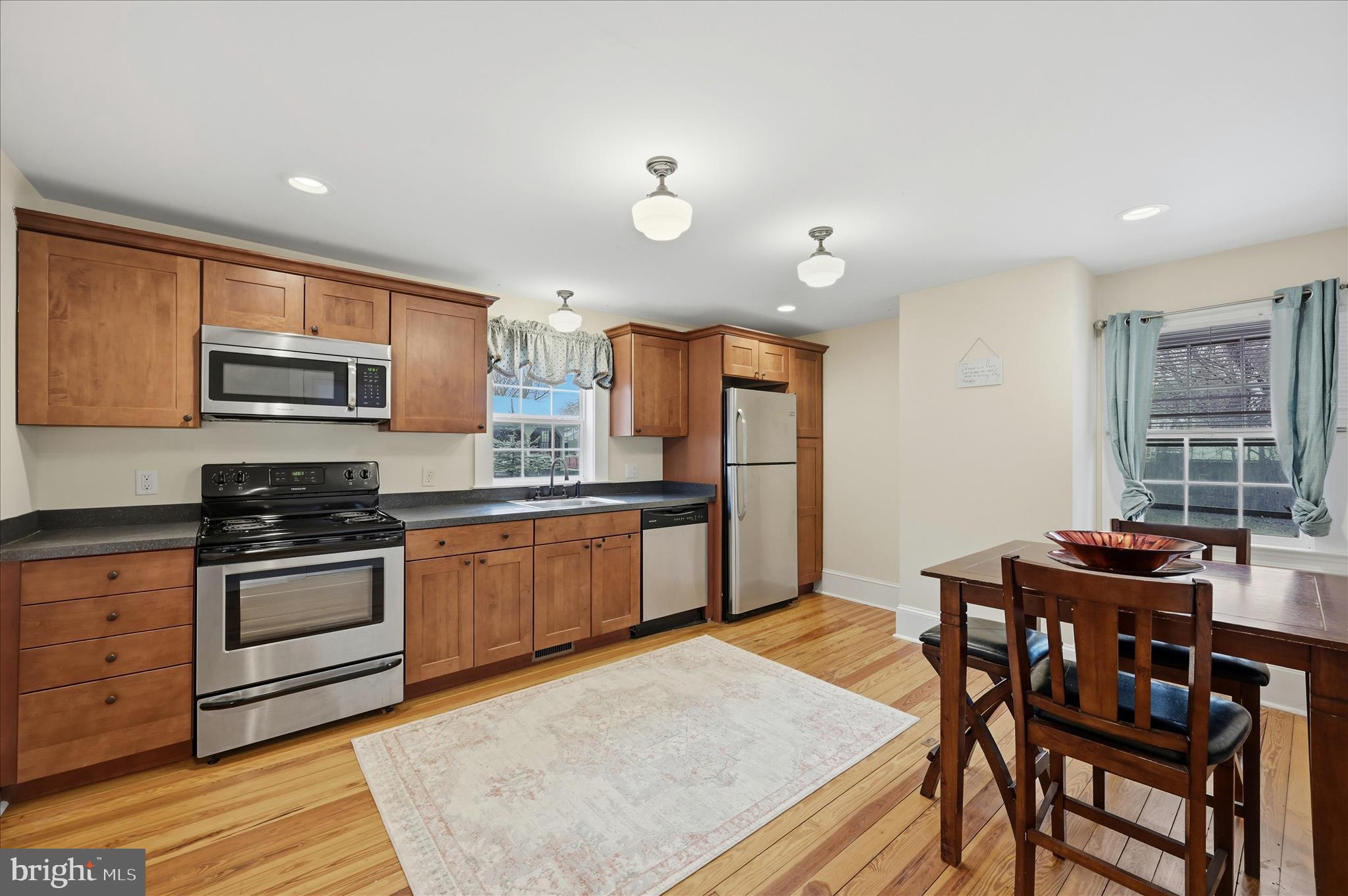 2 West Main Street Boyce, VA 22620 - Photo 22 of 65 a kitchen with stainless steel appliances granite countertop a stove top oven a sink a dining table and chairs with wooden floor