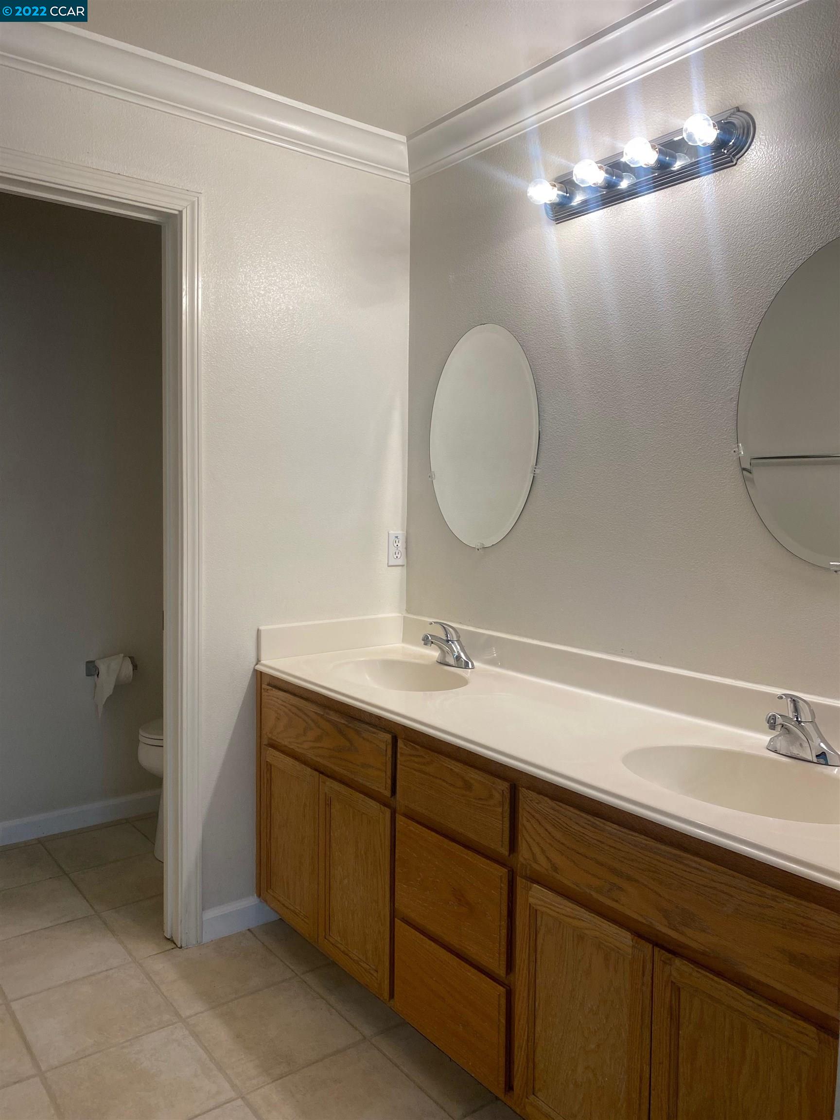 1317 Amaryllis Circle San Ramon, CA 94582 - Photo 14 of 24 a bathroom with a double vanity sink and a mirror