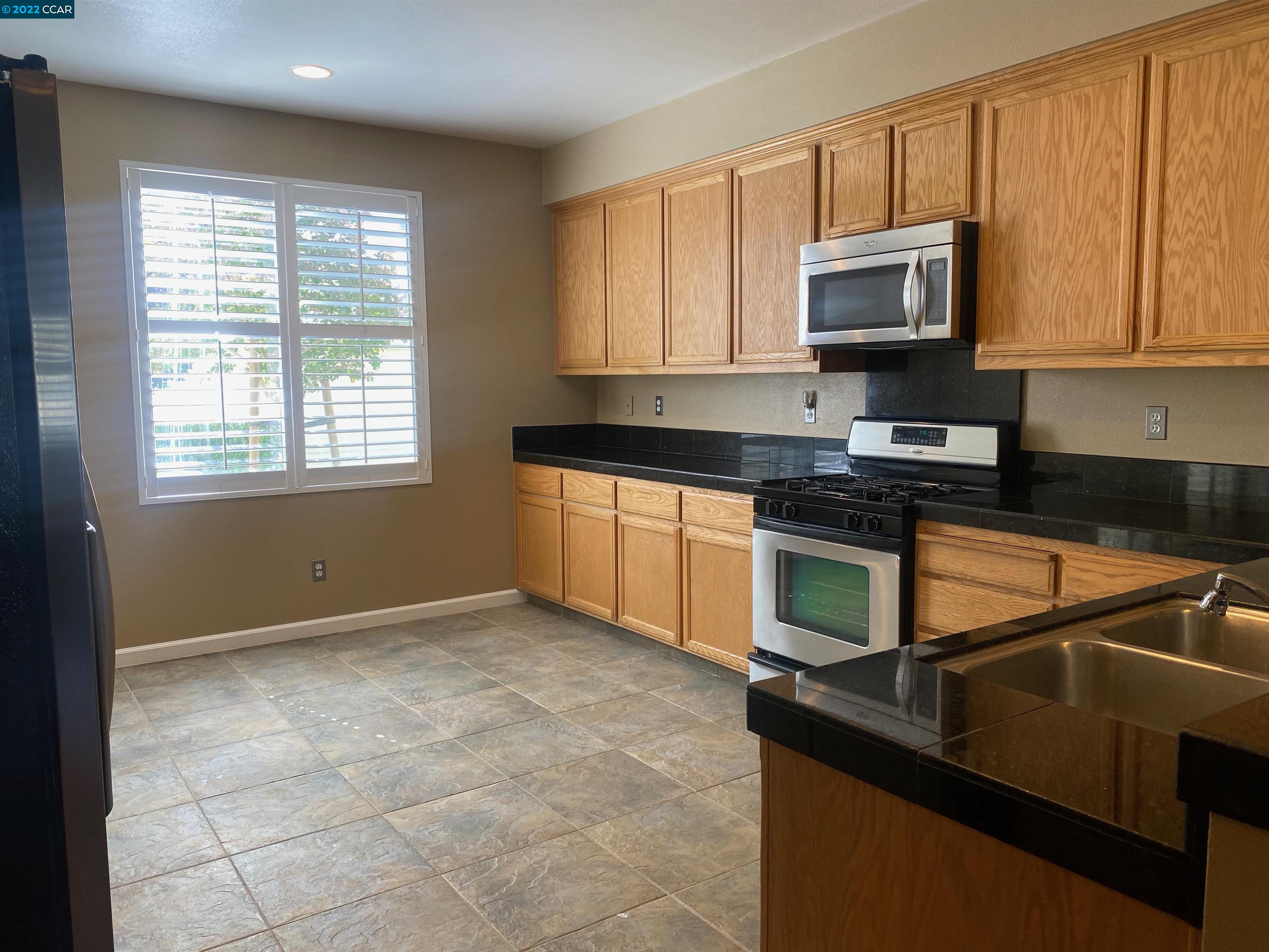 1317 Amaryllis Circle San Ramon, CA 94582 - Photo 8 of 24 a kitchen with granite countertop a stove a sink and a microwave