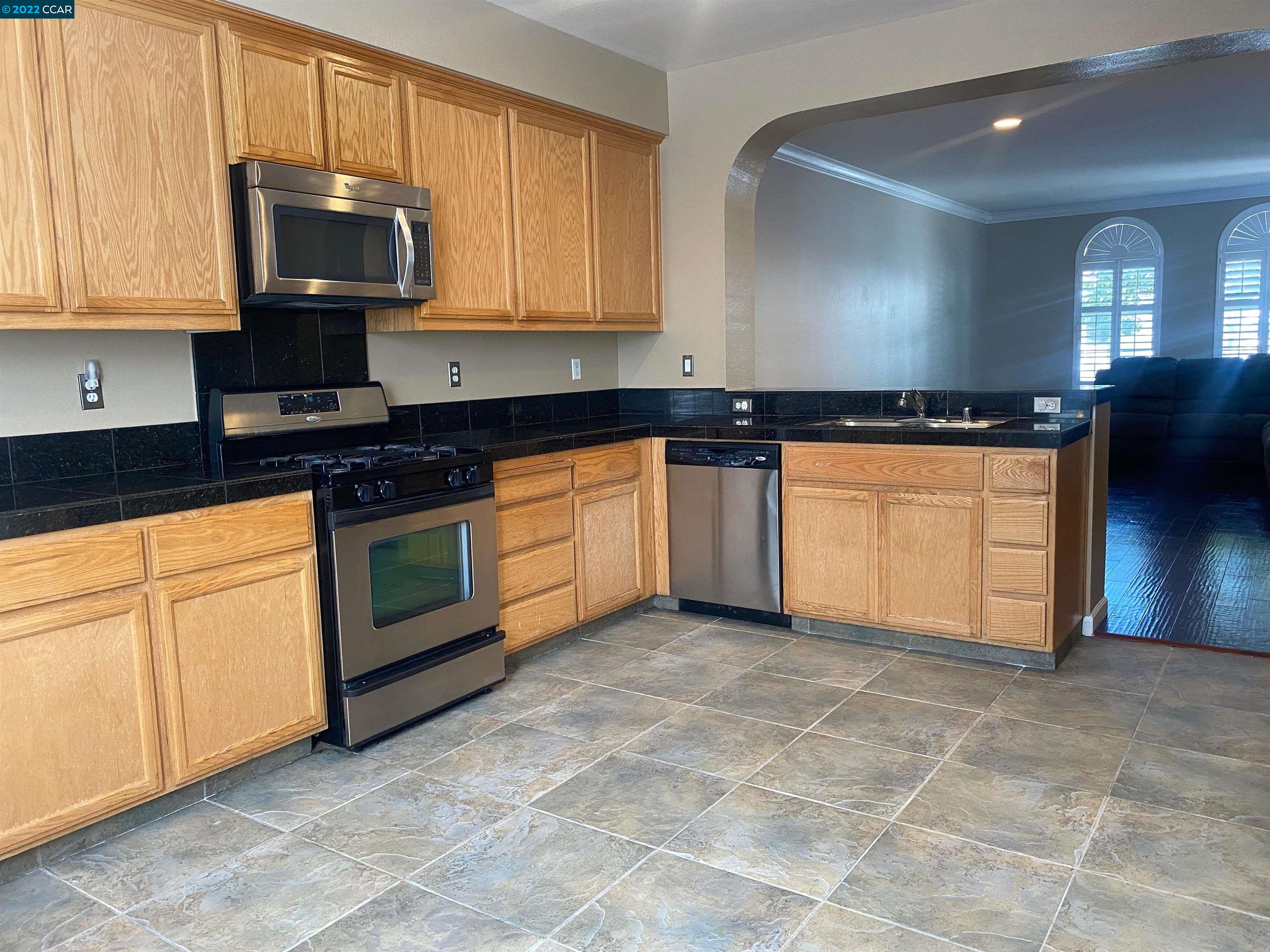 1317 Amaryllis Circle San Ramon, CA 94582 - Photo 9 of 24 a kitchen with stainless steel appliances granite countertop a stove a sink and a microwave