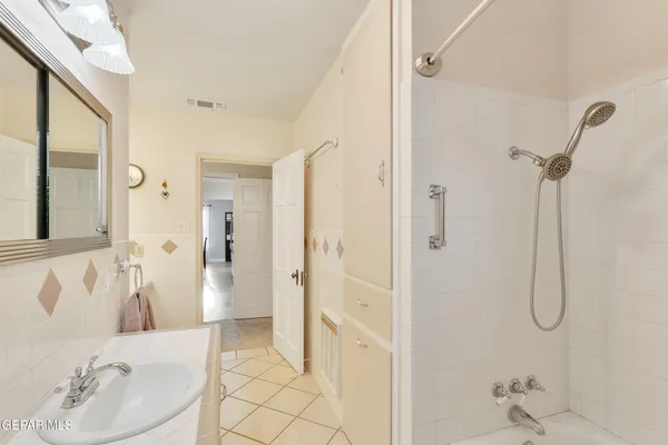 a bathroom with a sink vanity and shower