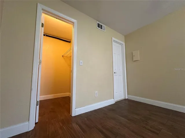 an empty room with wooden floor and a window