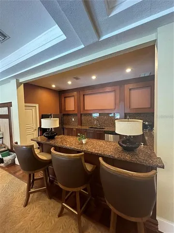 a kitchen with stainless steel appliances granite countertop a table chairs sink and cabinets