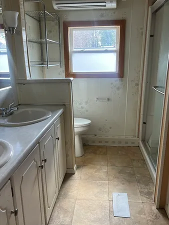 a bathroom with a granite countertop sink a toilet and a vanity