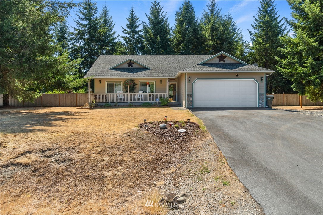 5037 180th Trail Southwest Rochester, WA 98579 - Photo 2 of 38 a front view of a house with a yard and garage