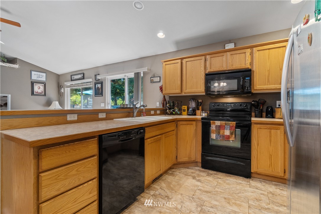 5037 180th Trail Southwest Rochester, WA 98579 - Photo 10 of 38 a kitchen with stainless steel appliances granite countertop a stove sink and microwave