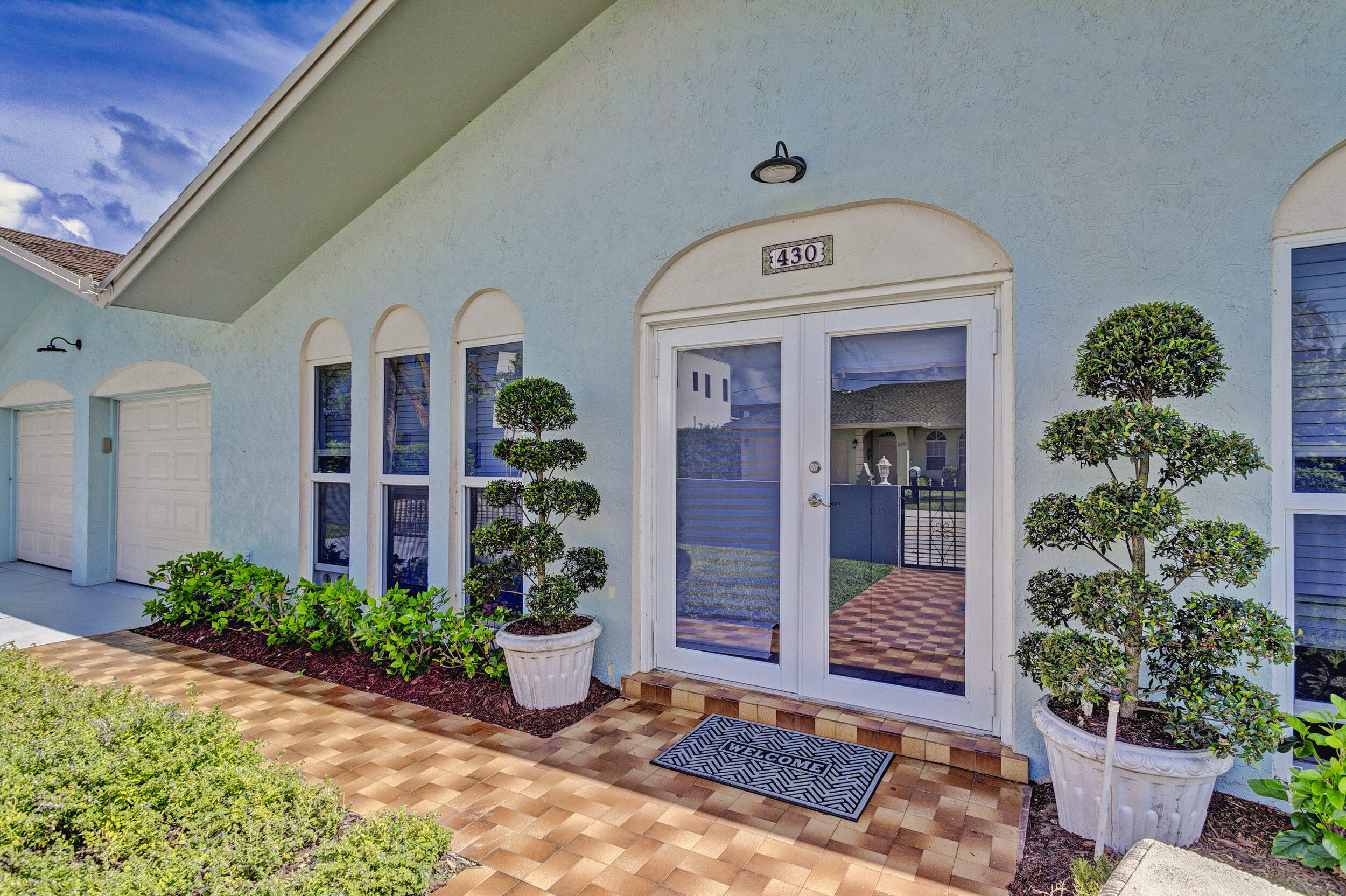 430 Mars Way Juno Beach, FL 33408 - Photo 11 of 65 a front view of a house with garden