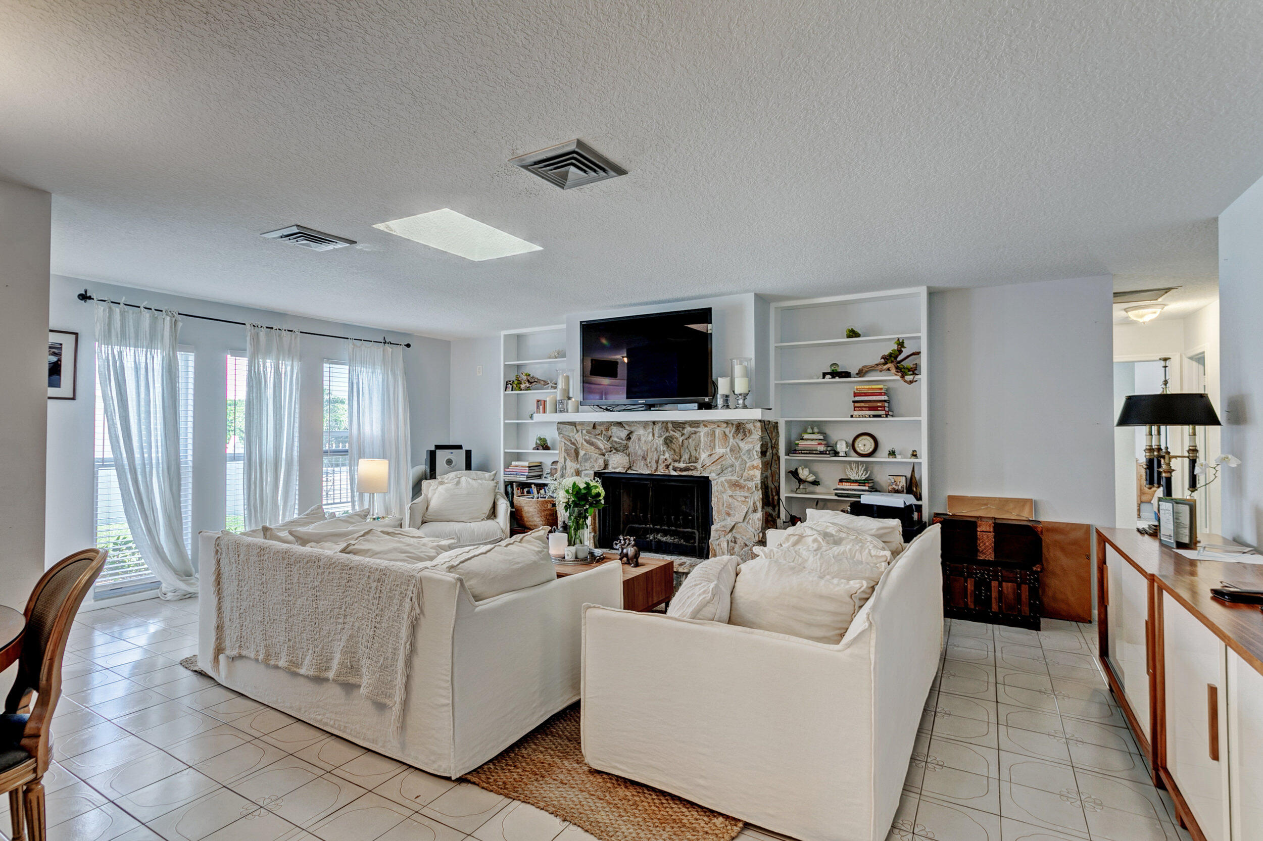 430 Mars Way Juno Beach, FL 33408 - Photo 17 of 65 a living room with furniture a fireplace and a flat screen tv
