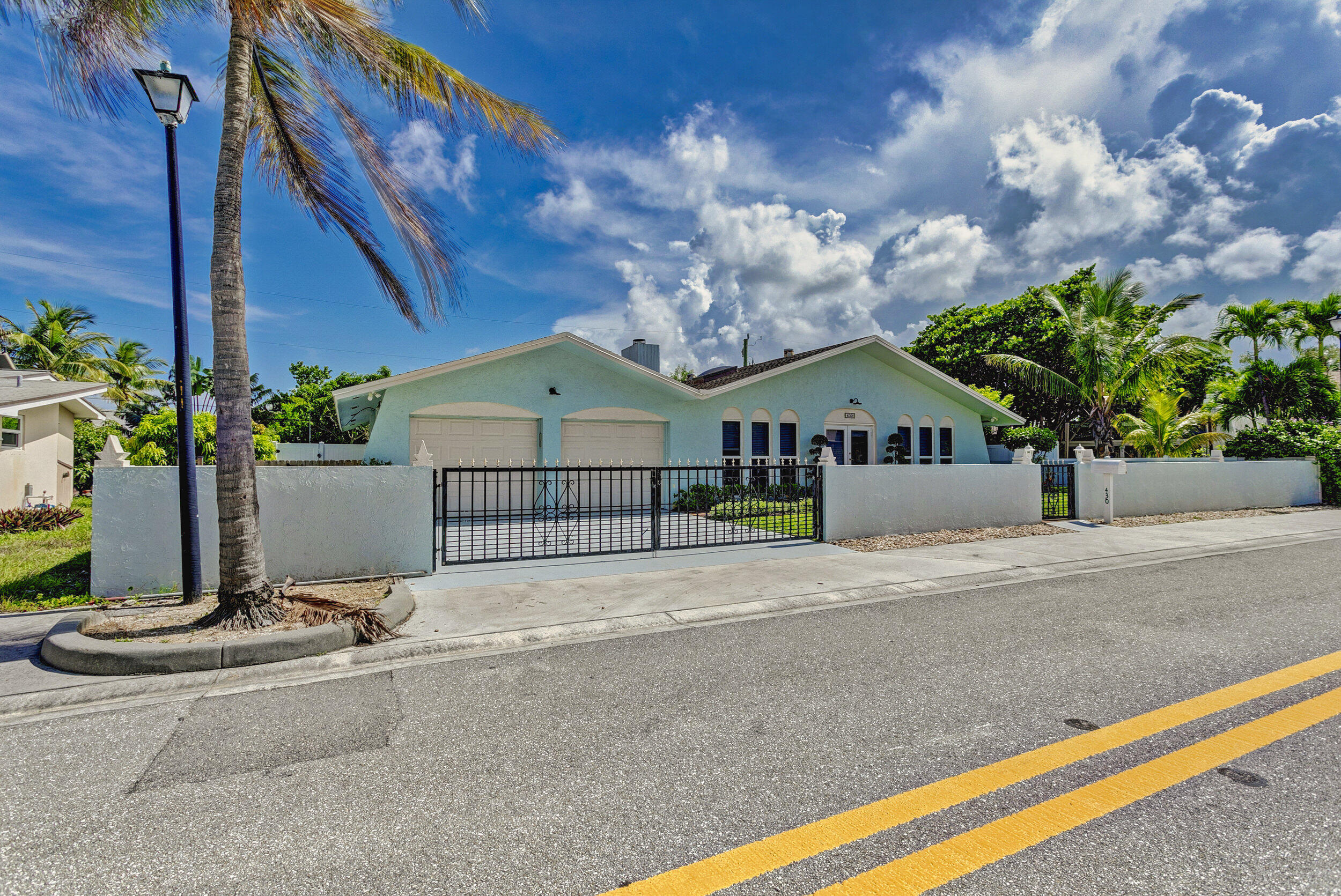 430 Mars Way Juno Beach, FL 33408 - Photo 3 of 65 a front view of a house with a garden