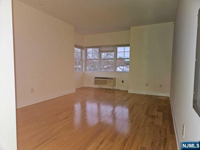 6 Madison Avenue, Unit 303 Cresskill, NJ 07626 - Photo 6 of 12 an empty room with wooden floor and windows
