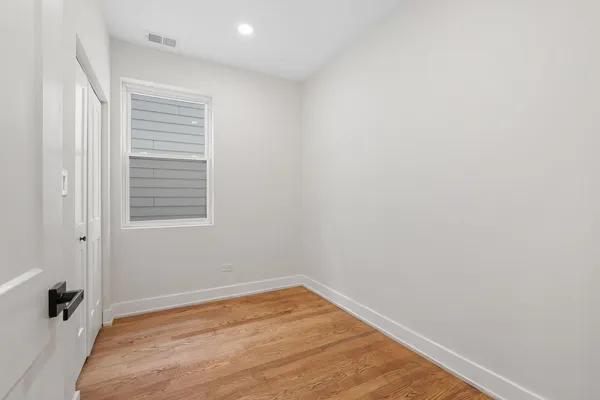 a view of a room with wooden floor and a window