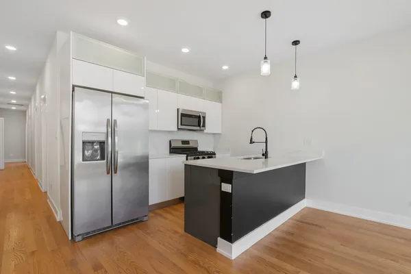 a view of kitchen with a sink a refrigerator and wooden floor