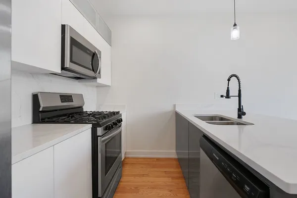 a kitchen with stainless steel appliances granite countertop a sink stove and microwave