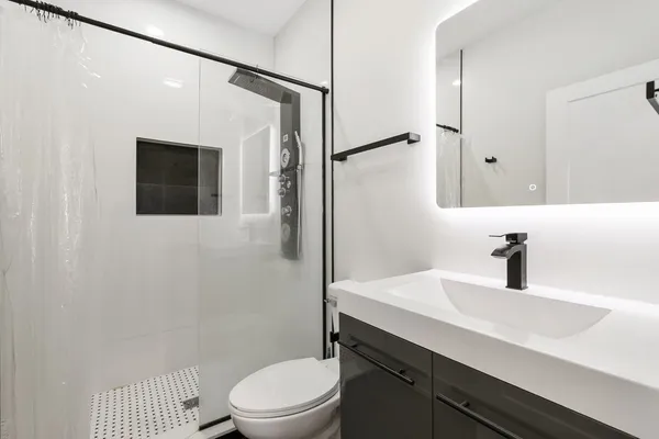 a bathroom with a sink a toilet and shower