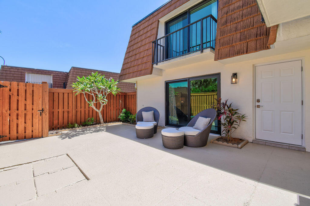 3900 County Line Road, Unit 22A Tequesta, FL 33469 - Photo 6 of 51 a view of a patio with potted plants and wooden fence