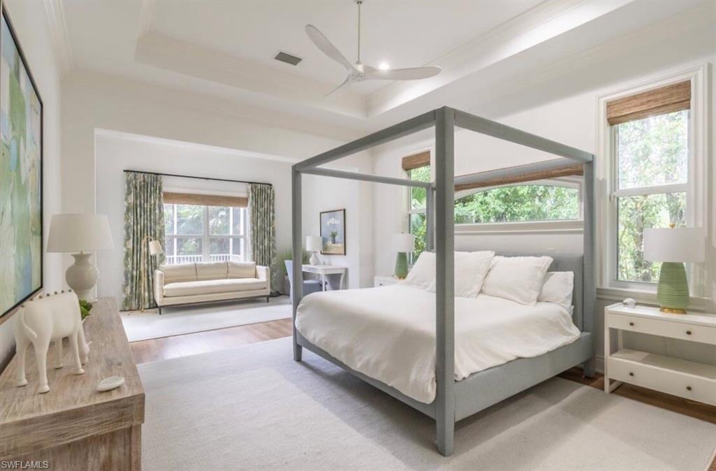 428 Rudder Road Naples, FL 34102 - Photo 22 of 49 Bedroom with light wood finished floors, a ceiling fan, a tray ceiling, and crown molding