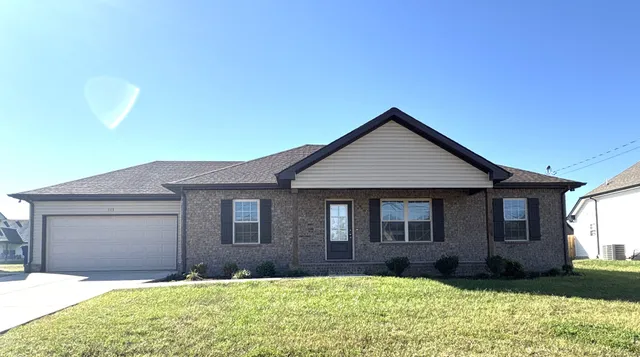 a front view of a house with a yard and garage