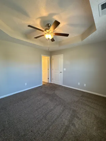 an empty room with a window and a fan