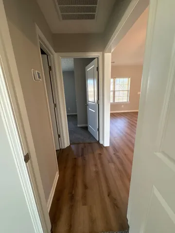 a view of hallway with wooden floor and stairs