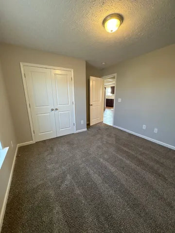 an empty room with an entryway and fan