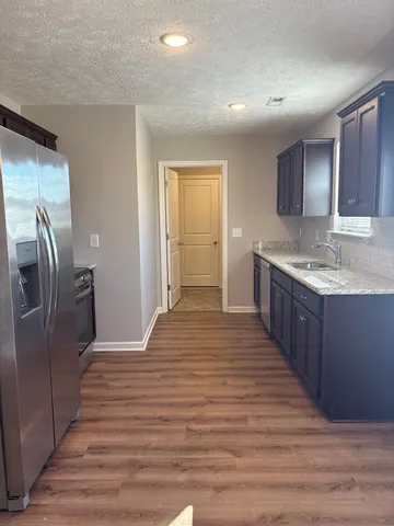 a kitchen with stainless steel appliances granite countertop a refrigerator and a sink