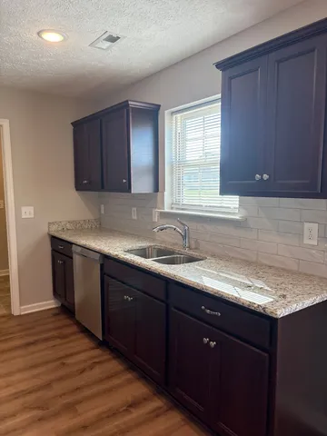 a kitchen with a sink cabinets and wooden floor