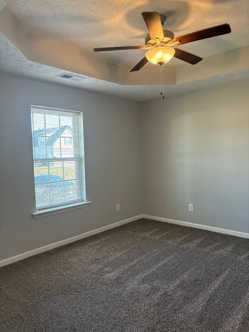 an empty room with a window and a fan