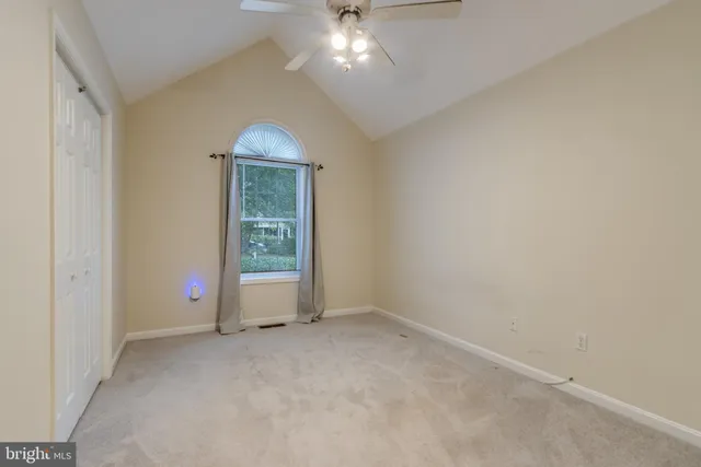 an empty room with chandelier fan