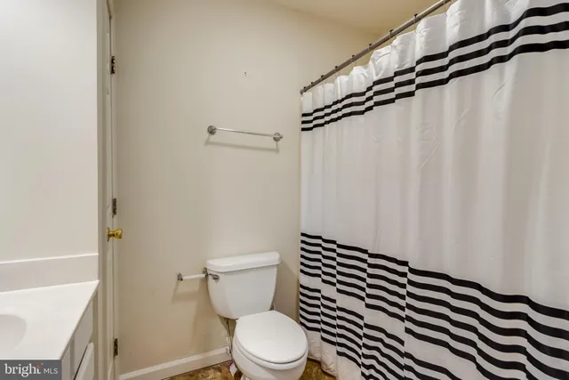 a white toilet sitting next to a shower curtain