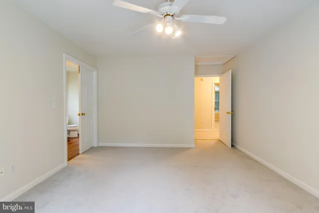 an empty room with closet and a chandelier fan