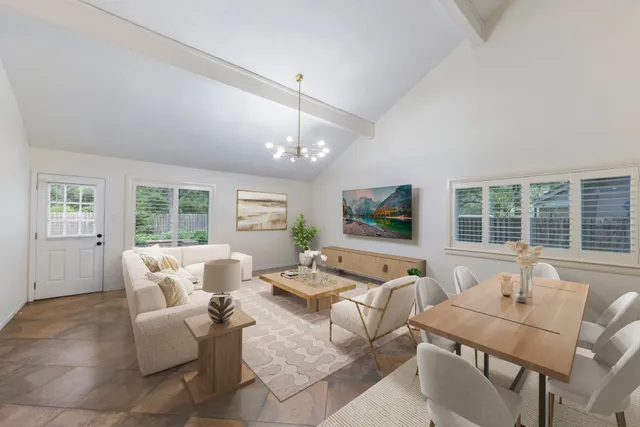 a living room with furniture large window and flat screen tv