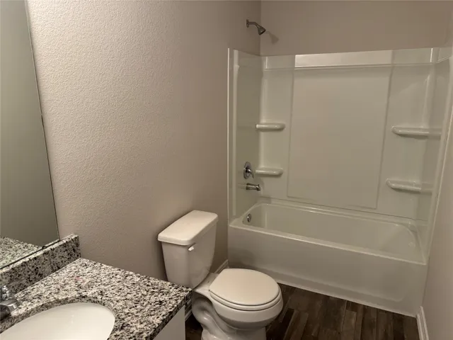 a white toilet sitting next to a bath tub