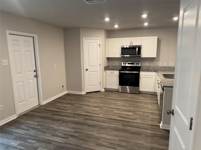 a large kitchen with stainless steel appliances granite countertop a stove and a refrigerator