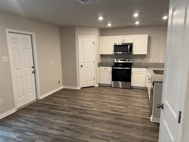 a large kitchen with stainless steel appliances granite countertop a stove and a refrigerator